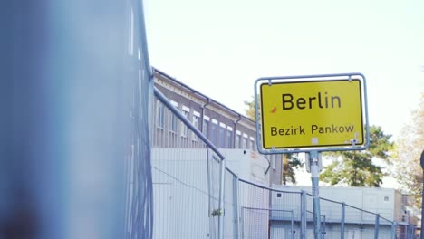 berlin city sign next to fence on bright sunny day in slow motion