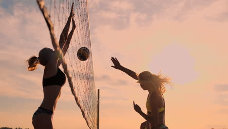 Group-of-young-girls-playing-beach-volleyball-during-sunset-or-sunrise