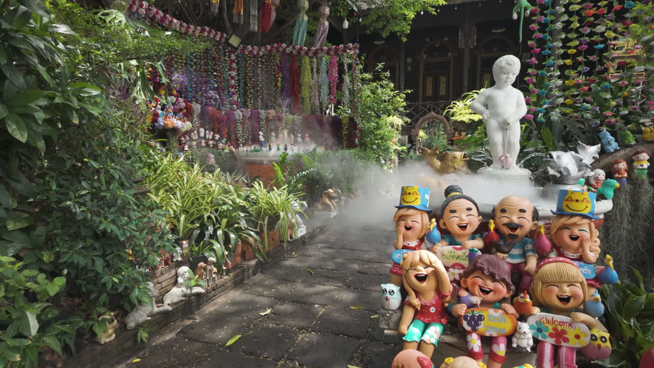 Outdoor Garden At Wat Ket Karam With Lush Greenery And Cheerful Cartoon-like Figurines. Chiang Mai, Thailand. tilt-up shot