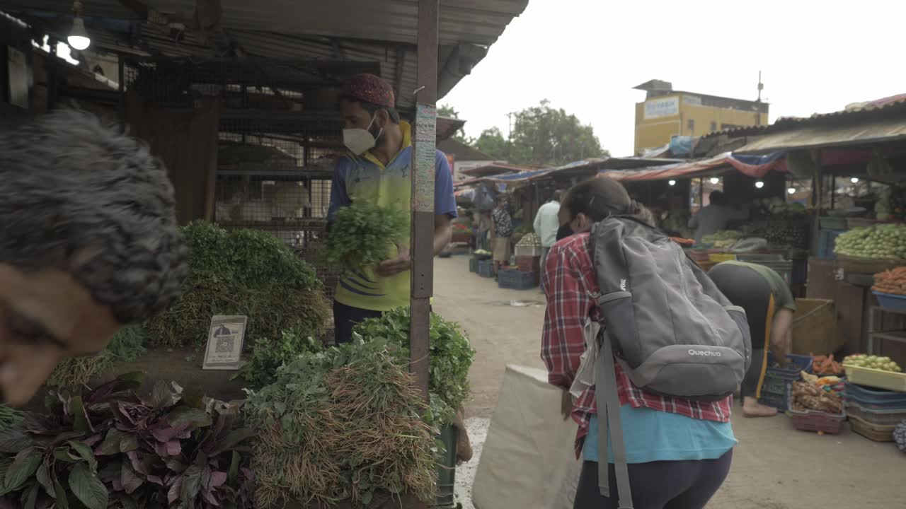 A young indian woman buying vegetables at the local farmers market for stocking vegetables and other essentials before curfew time in the second wave lockdown in India