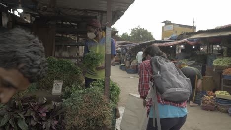 a young indian woman buying vegetables at the local farmers market for stocking vegetables and other essentials before curfew time in the second wave lockdown in india
