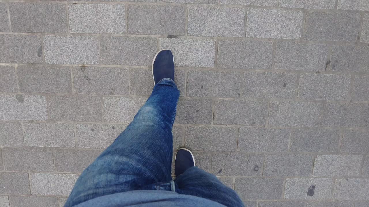 una persona caminando por una calle de adoquines