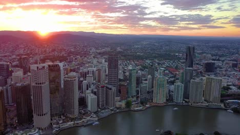 Aerial-view-of-a-city-riverside-at-sunset-with-clouds
