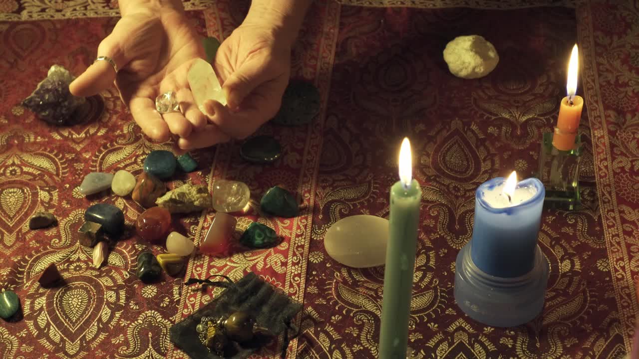 Close-up shot of a witch's hands showing quartz and magic stones with energy for use in mystical rituals