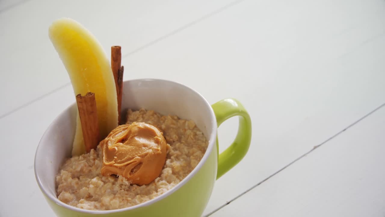 Tazza di avena con burro di arachidi, banana e stecche di cannella 4k