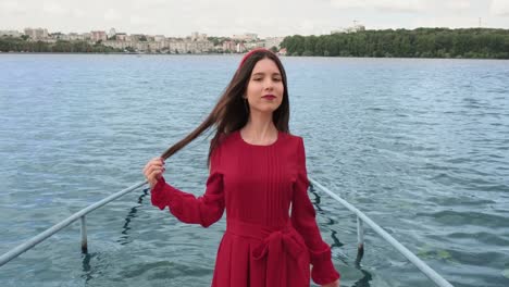 beautiful cheerful positive girl in red smiling by the lake