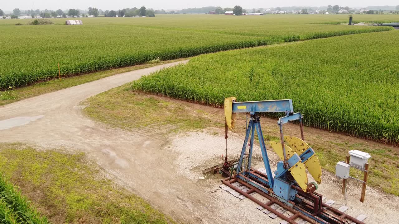 미시간주 이사벨라 카운티 마운트 프레이트 근처의 옥수수 밭 한가운데에 있는 펌프잭 - 공중 정적 샷