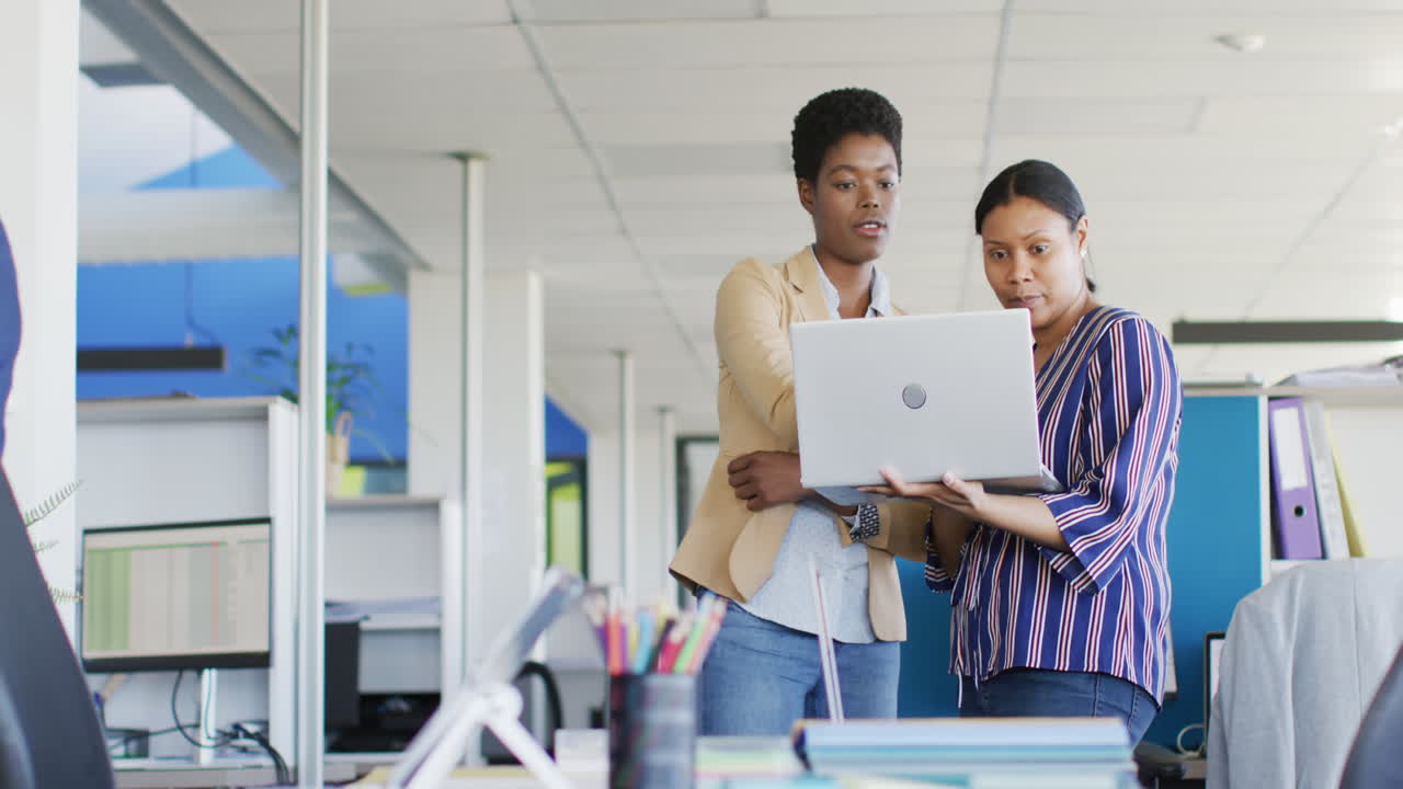 African american business people using laptop at office, slow motion