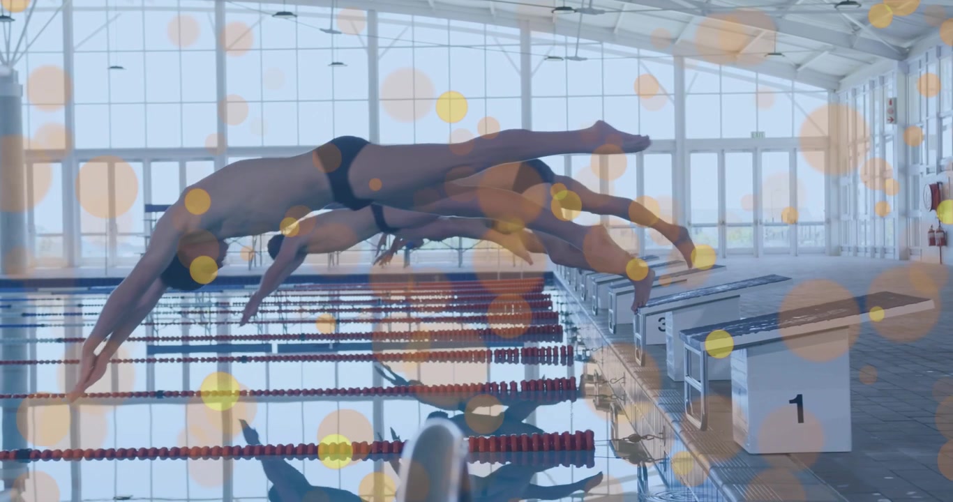 Male swimmers crouching on blocks, launching dive at start signal into water for competition