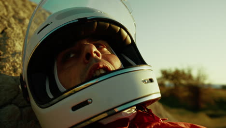 tired astronaut with helmet breathing heavy on a rock in hostile planet