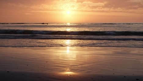 El-Amanecer-Dorado-Se-Refleja-En-La-Playa-De-Arena-Mientras-Las-Olas-Ondulan