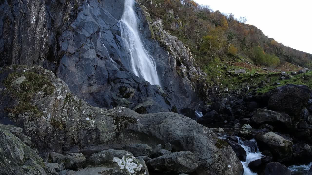 Cascata rocciosa che scorre tra rocce frastagliate del fiume e massi, timelapse.