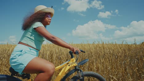 girl cycling in a wheat field