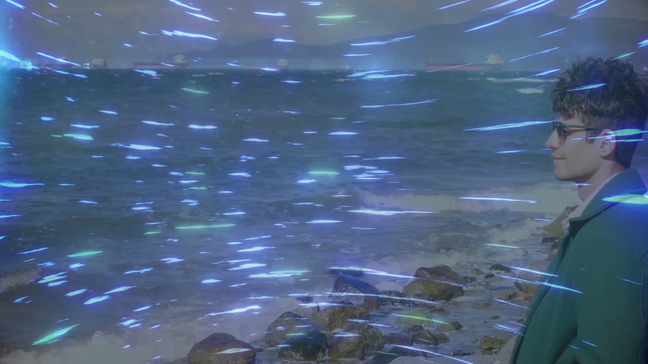 Person wearing sunglasses standing by rocky shore with swirling blue light animation