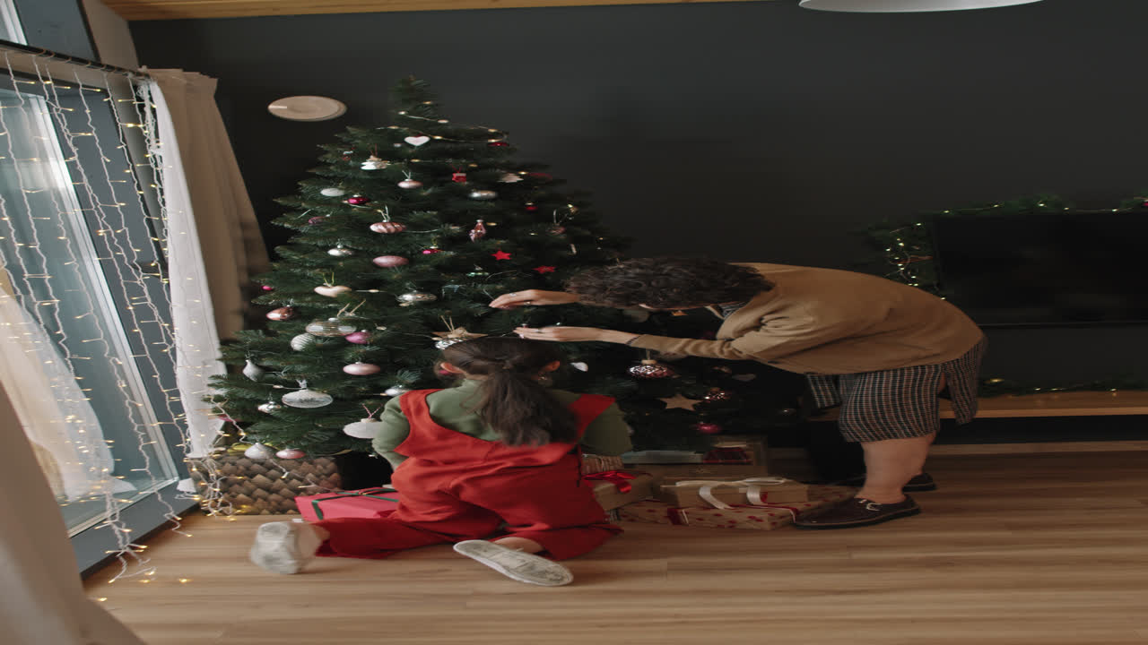 mamá y hija decorando el árbol de navidad