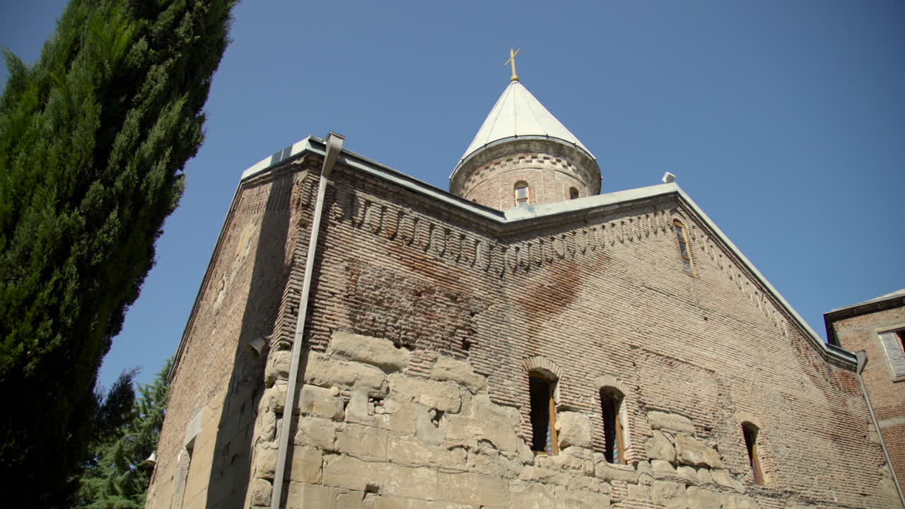 루지 수도원에 있는 12세기 조지아 정교회 또는 트빌리시 조지아에 있는 "푸른 교회"의 나무를 내려다보는 낮은 각도