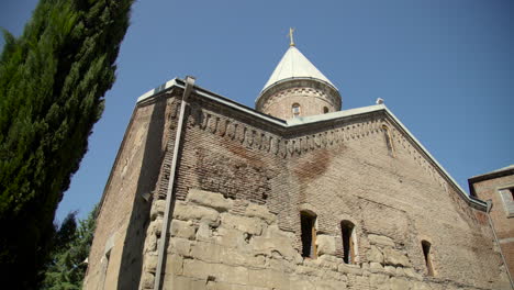 una vista de ángulo bajo sobre los árboles de la iglesia ortodoxa georgiana del siglo xii en el monasterio lurji, o &quot;iglesia azul&quot;, en tbilisi, georgia