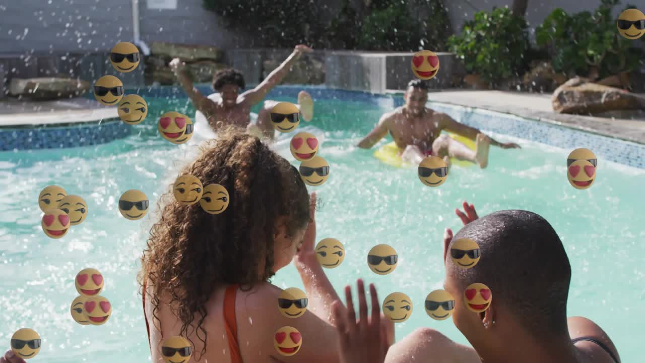 Amici che galleggiano su ciambelle in piscina in giardino con emoji fluttuanti mentre uomini pagaiando creano schizzi per svago