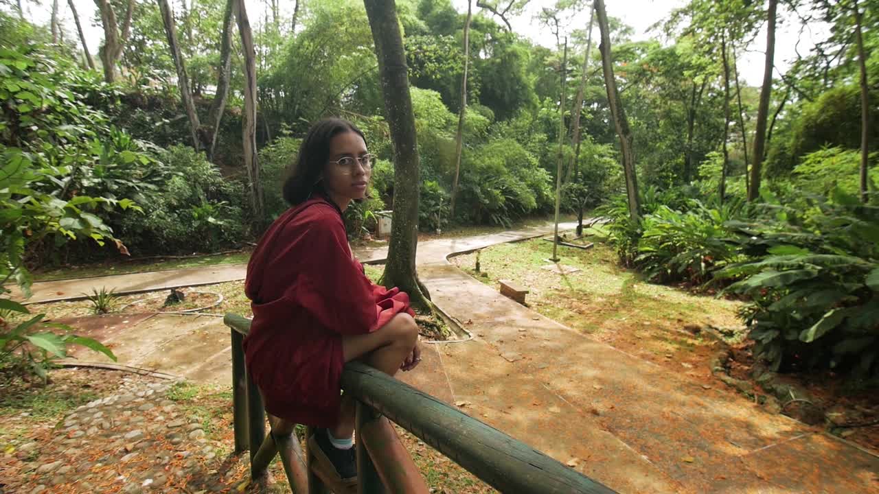 niña sentada en un puente de madera fondo de hojas de naranja