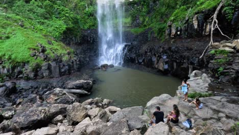 personas disfrutando de una cascada en un bosque exuberante