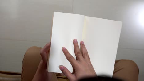 senior woman reading a book on sofa