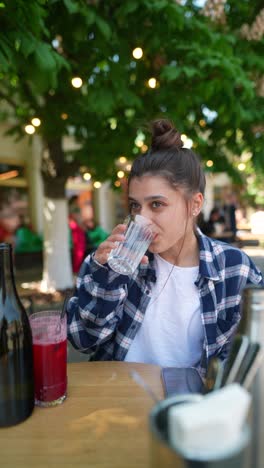 young woman enjoying a drink outdoors at a cafe