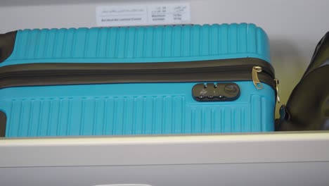 Blue Suitcase in Airplane Storage