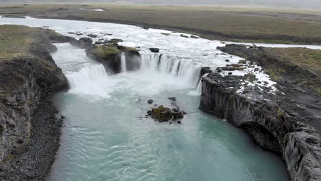 luftaufnahme in richtung blauer grüner wasserfall des godafoss-gletschers in island