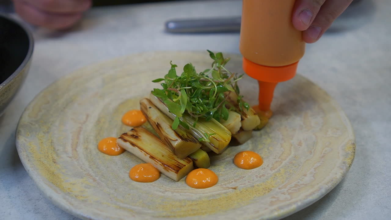 Gegrilde prei met saus en spruitjes.