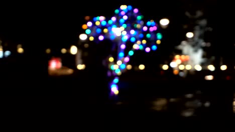 a seller of colored balls is walking along a dark street, out of focus