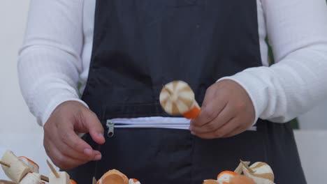 young woman making suki satay and put sausage on skewer