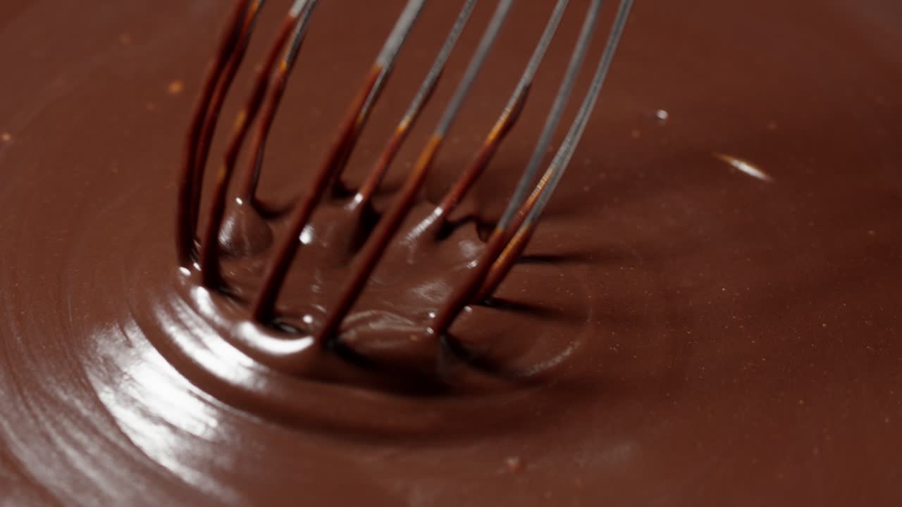 chocolatier hacer postre amargo orgánico hecho a mano con nueces, mezclando, agitando chocolate derretido