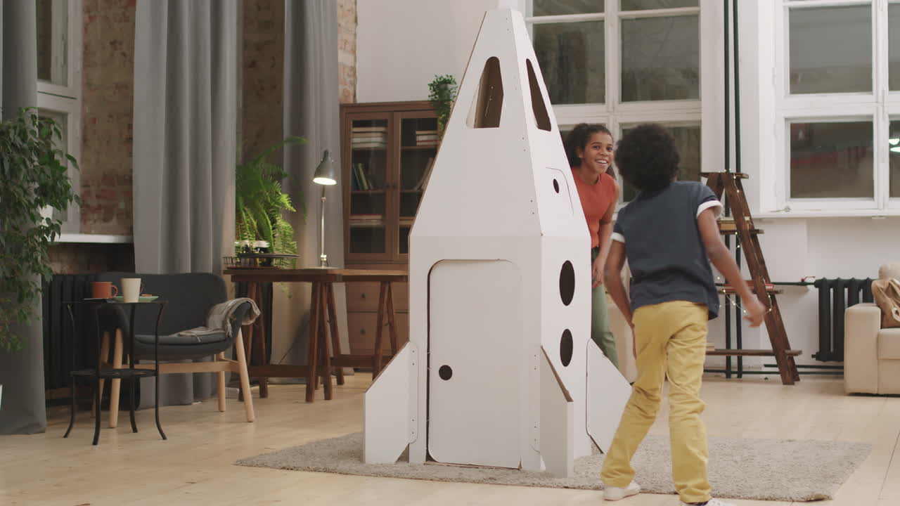 Afro Kids Running Around Cardboard Rocket Ship