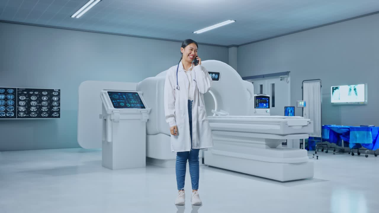 Full Body Of Asian Woman Doctor With Stethoscope Talking On Smartphone While Standing With Mri Machine In The Hospital