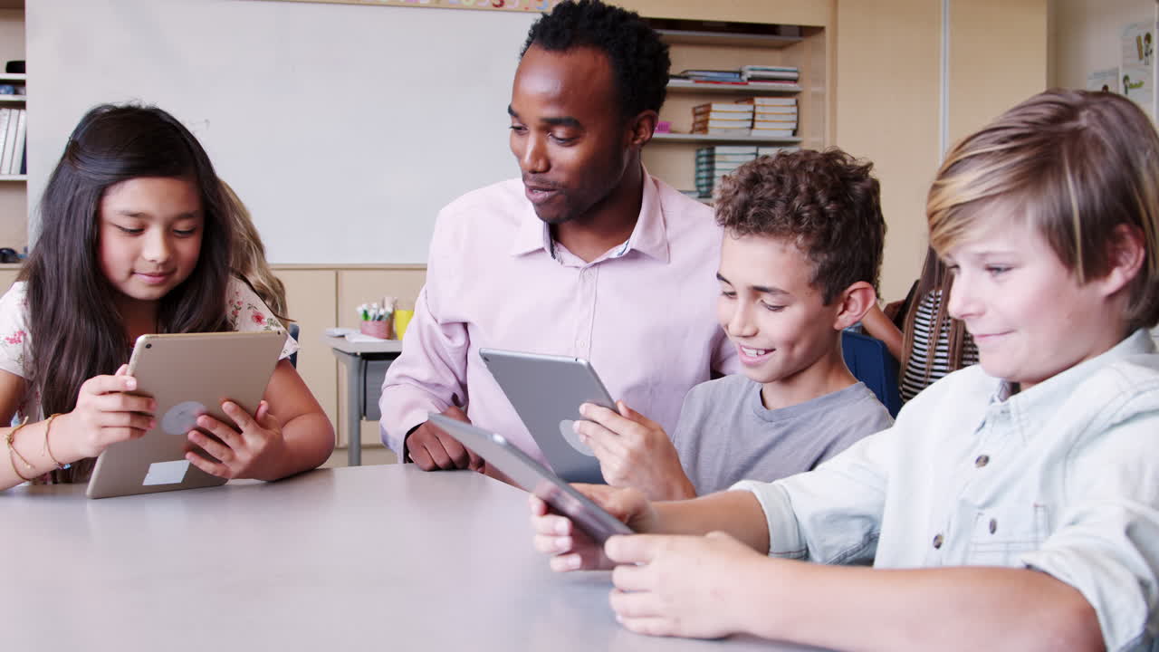 maestro entre los niños con tabletas en la clase de escuela primaria