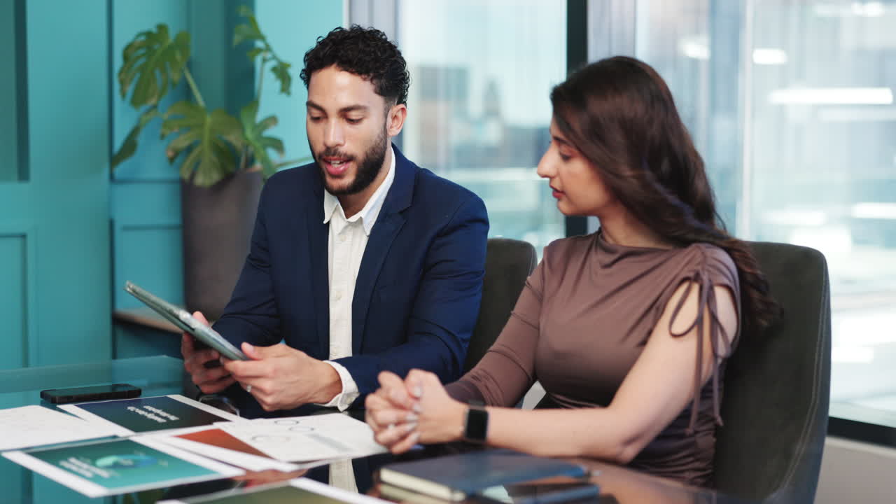 Colegas de negocios discutiendo un proyecto en una tableta en una oficina moderna