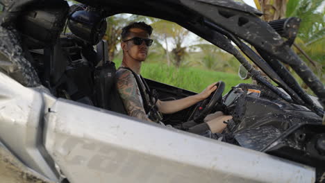 Varón-Caucásico-Sentado-En-Un-Buggy-Con-Gafas-De-Sol-Girando-Hacia-La-Cámara-En-Punta-Cana