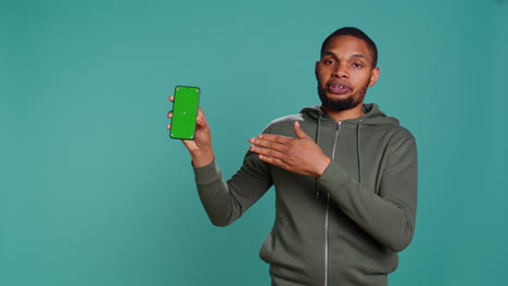 Portrait-of-man-doing-influencer-marketing-using-green-screen-phone