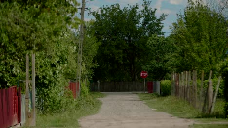 Stop-sign-at-the-end-of-dirt-path,-countryside-road