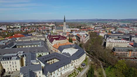 aerial drone over european city of olomouc with rooftops and church steeple on clear day in autumn in czech republic