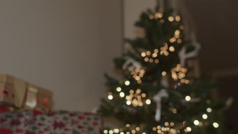 regalos de navidad bajo el árbol de navidad con luces, inclinación, de mano, de ancho medio