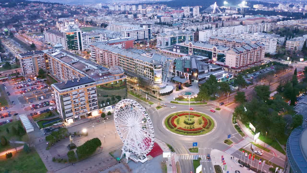 podgorica montenegro por la noche. paisaje urbano nocturno de la capital de un pequeño país de los balcanes, en el sureste de europa. tráfico en la rotonda en el centro residencial y comercial de la ciudad.