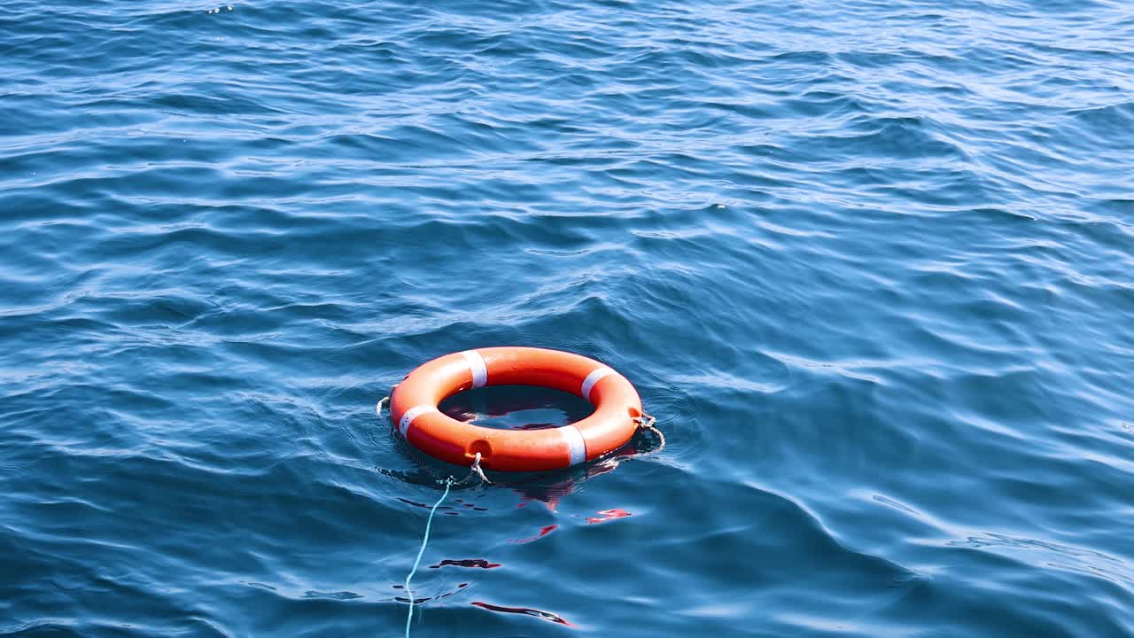 una boya salvavidas flota en las serenas olas del océano bajo la brillante luz del día, creando una escena marítima tranquila