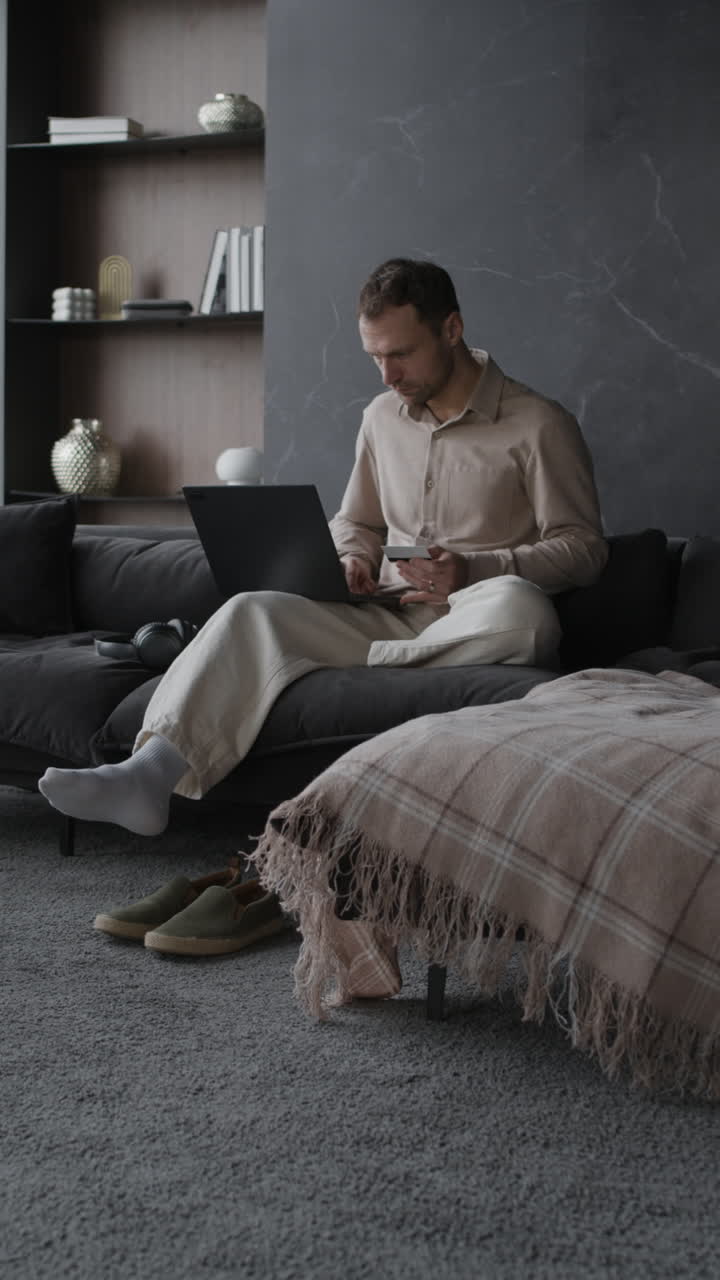 hombre trabajando en una computadora portátil en la sala de estar