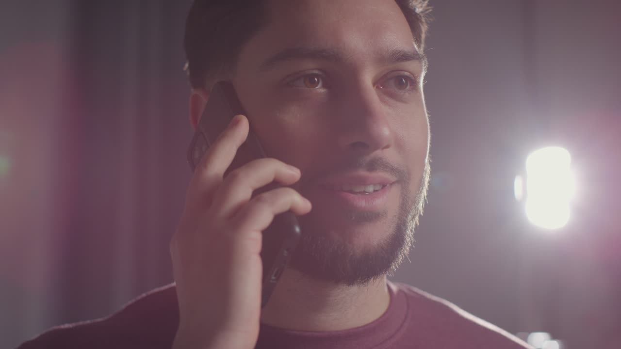 joven complacido en casa recibiendo una llamada telefónica que confirma la oferta de trabajo 6