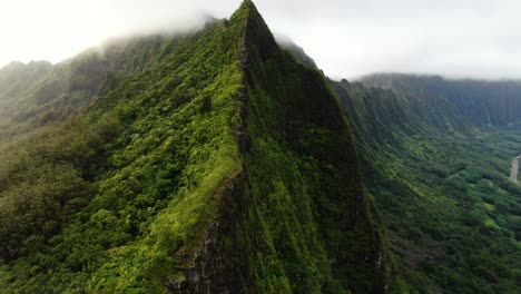 Drone-parallax-around-hawaiian-mountain-range-as-rain-clouds-cover-the-ridge