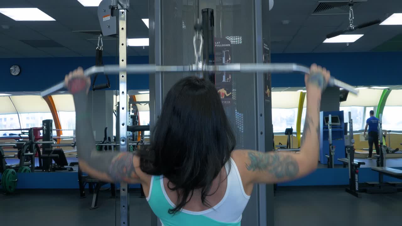 mujer haciendo ejercicio de lat pulldown en el gimnasio