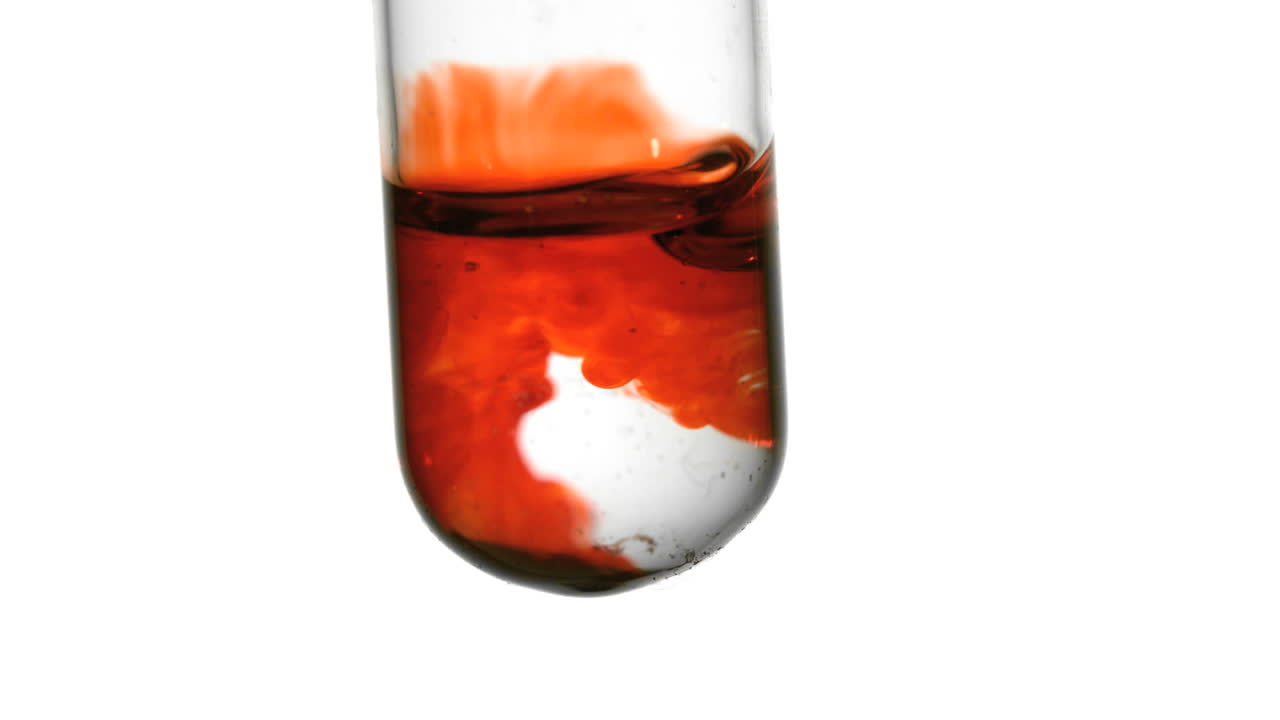 색 배경에 가까이 물의 시험관에 떨어지는 피 한 방울