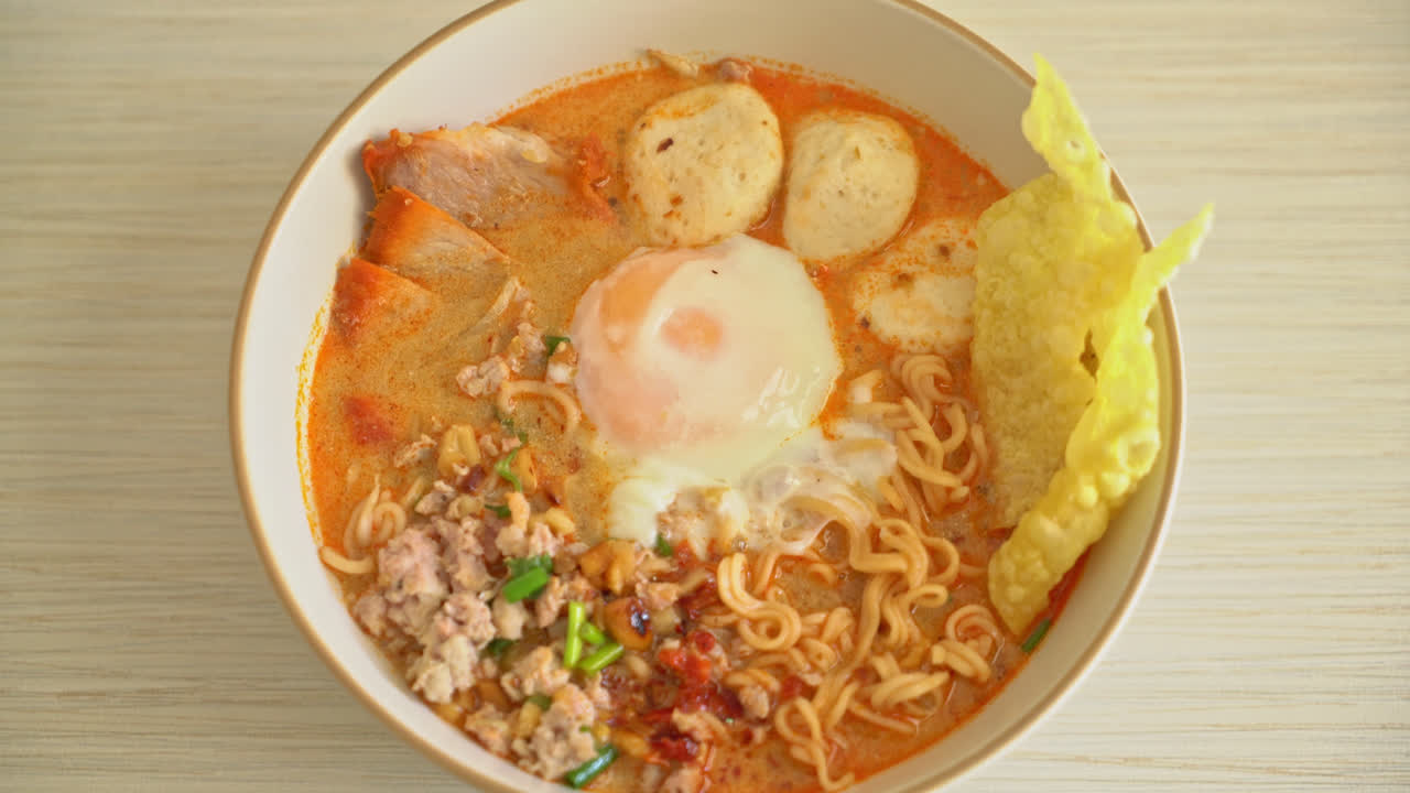 fideos instantáneos con carne de cerdo y albóndigas en sopa picante o fideos tom yum al estilo asiático