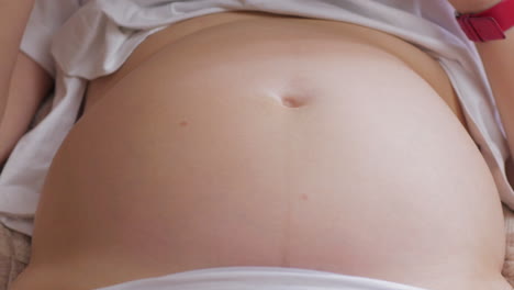 pregnant womans belly with baby moving and kicking inside